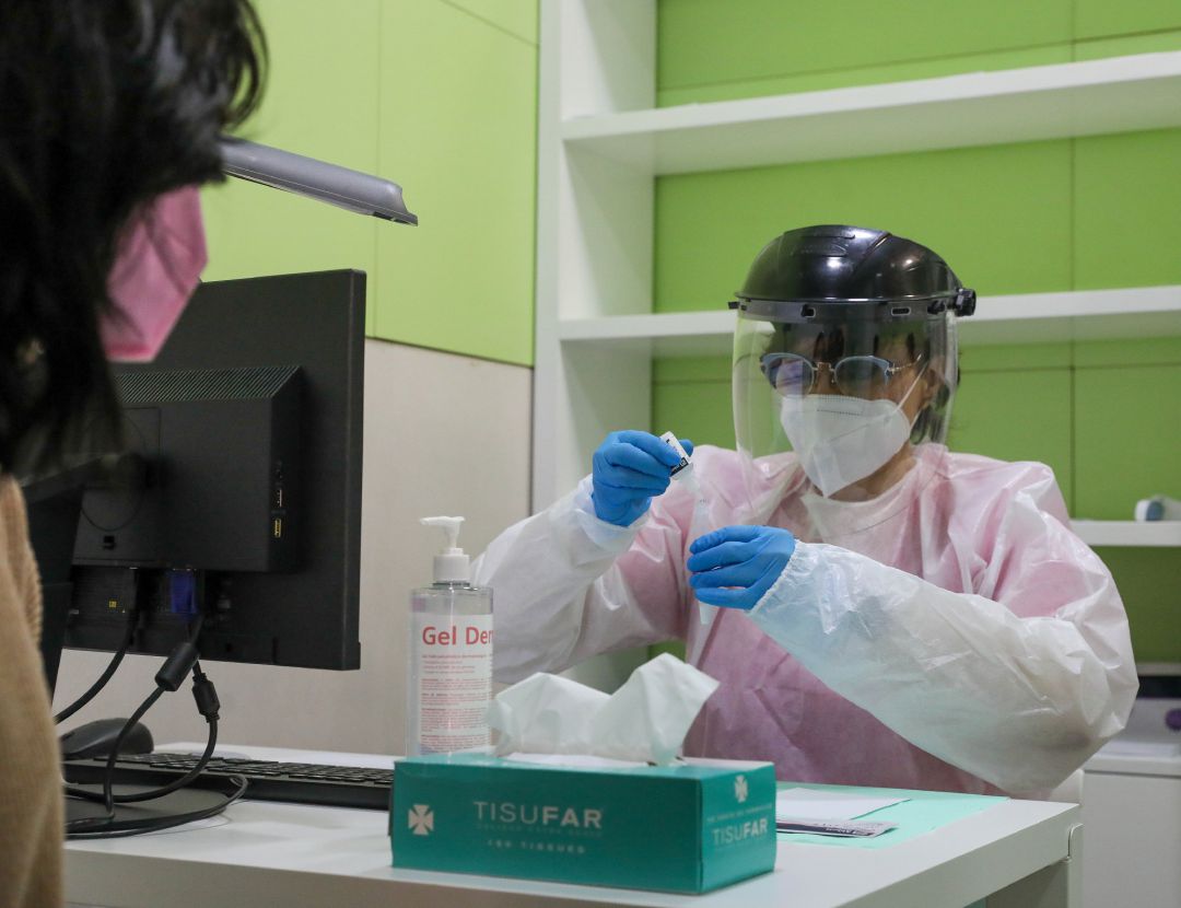 Una trabajadora sanitaria atiende a una mujer antes de realizarse un test de antígenos en una farmacia Una trabajadora sanitaria atiende a una mujer antes de realizarse un test de antígenos en una farmacia