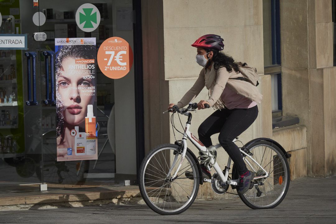 Una mujer con mascarilla y bici en una céntrica calle de Pamplona, Navarra (España) a 17 de julio de 2020 Una mujer con mascarilla y bici en una céntrica calle de Pamplona, Navarra (España) a 17 de julio de 2020
