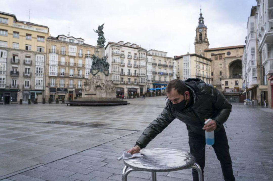 Un hostelero desinfecta una de las mesas de su terraza en el centro de Vitoria Un hostelero desinfecta una de las mesas de su terraza en el centro de Vitoria