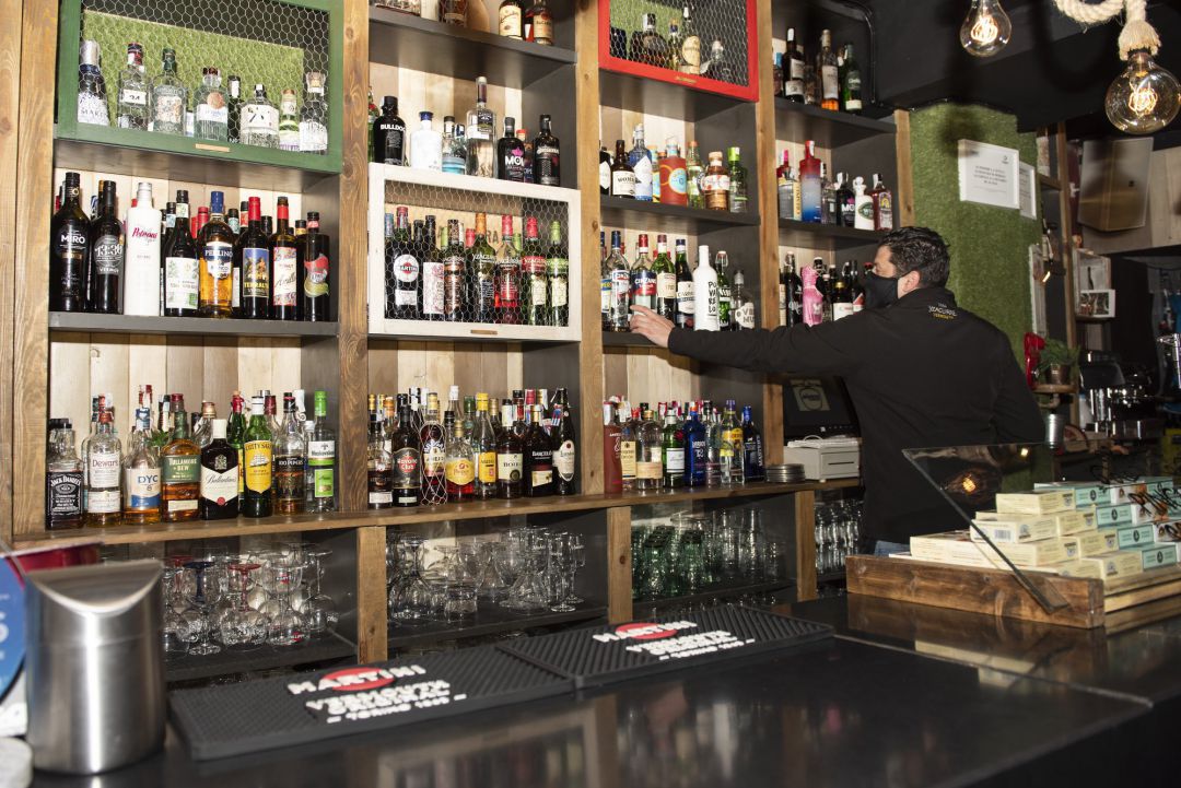 Un camarero trabaja en el interior de un bar Un camarero trabaja en el interior de un bar