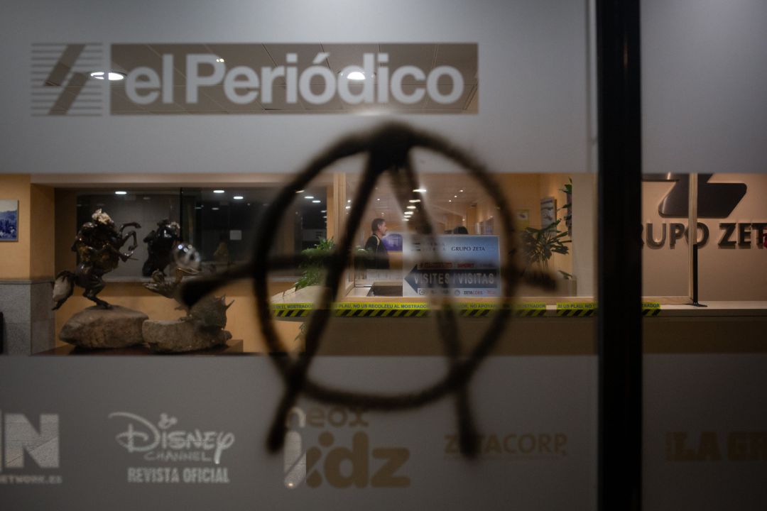 Pintada con el símbolo de la anarquía en la sede de El periodico de Catalunya tras la manifestación por el encarcelamiento del rapero y poeta Pablo Hasel. Pintada con el símbolo de la anarquía en la sede de El periodico de Catalunya tras la manifestación por el encarcelamiento del rapero y poeta Pablo Hasel.