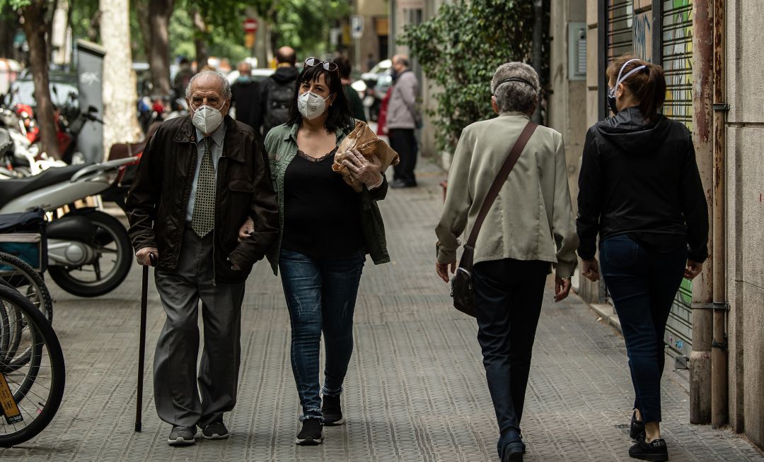 Personas paseando con mascarillas. Personas paseando con mascarillas.