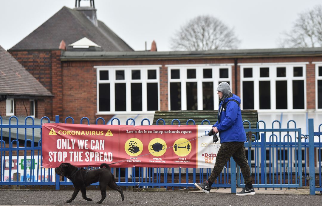 Una persona pasea a su perro frente a un cartel que advierte de las medidas para evitar la expansión de la COVID-19 Una persona pasea a su perro frente a un cartel que advierte de las medidas para evitar la expansión de la COVID-19