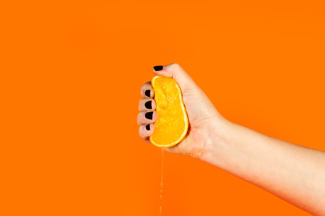 Una mano exprime una naranja Una mano exprime una naranja