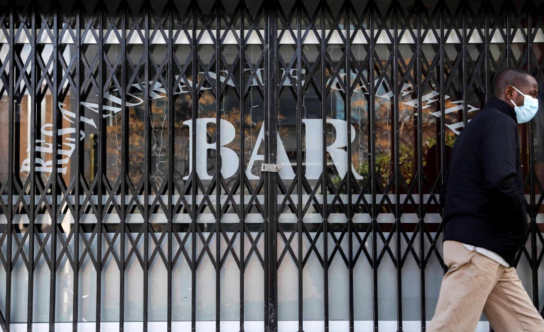 Una persona pasa por delante de un bar Una persona pasa por delante de un bar