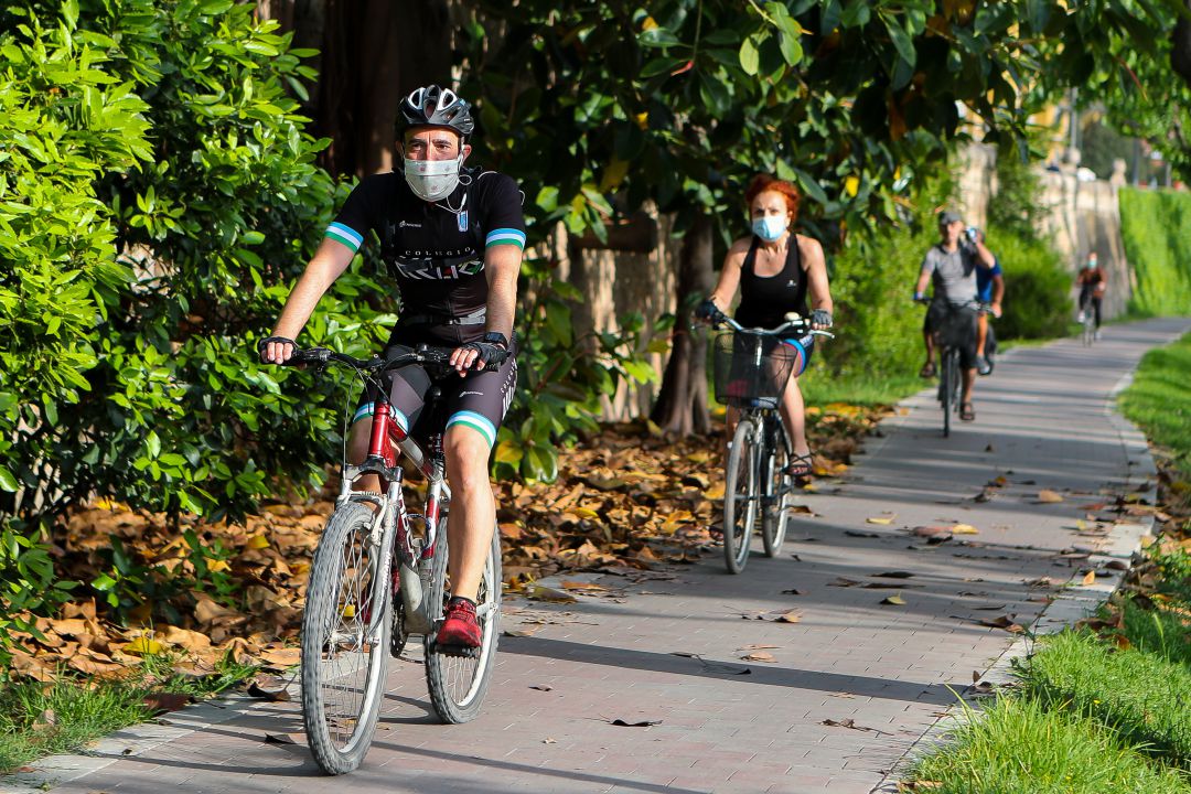 Tres ciclistas circulan por el parque del Túria en la ciudad de València Tres ciclistas circulan por el parque del Túria en la ciudad de València