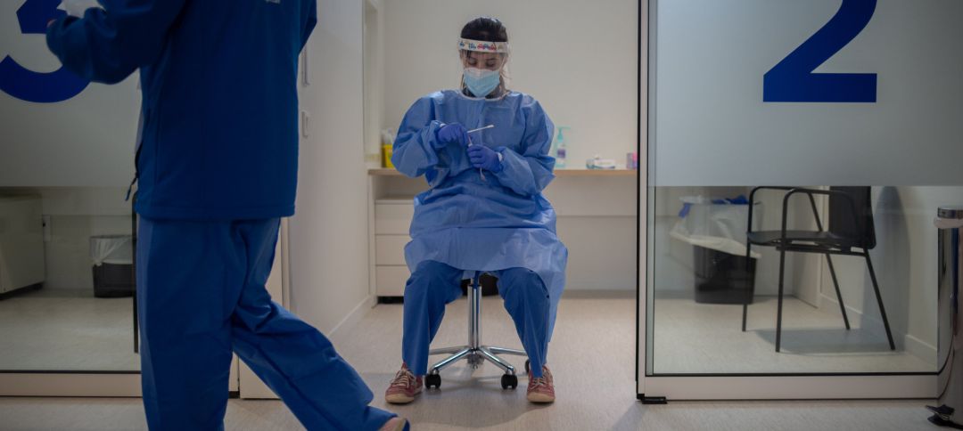Una profesional sanitaria sostiene muestras de pruebas PCR Una profesional sanitaria sostiene muestras de pruebas PCR