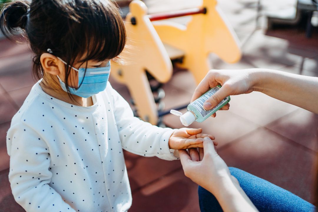 Niña con mascarilla y gel hidroalcohólico Niña con mascarilla y gel hidroalcohólico