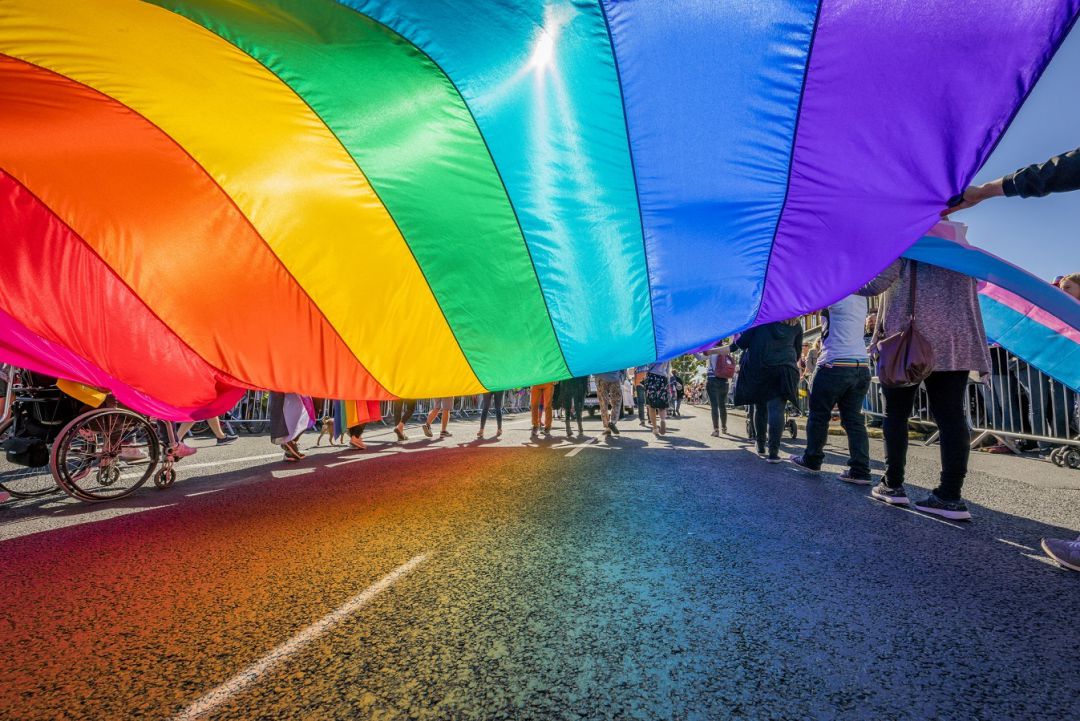 Jóvenes portando una bandera LGTBI Jóvenes portando una bandera LGTBI