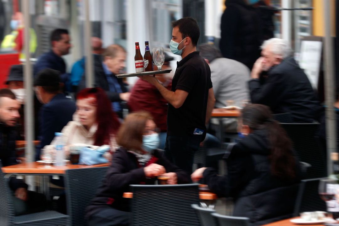 Imagen de archivo de un camarero sirviendo consumiciones en una terraza Imagen de archivo de un camarero sirviendo consumiciones en una terraza