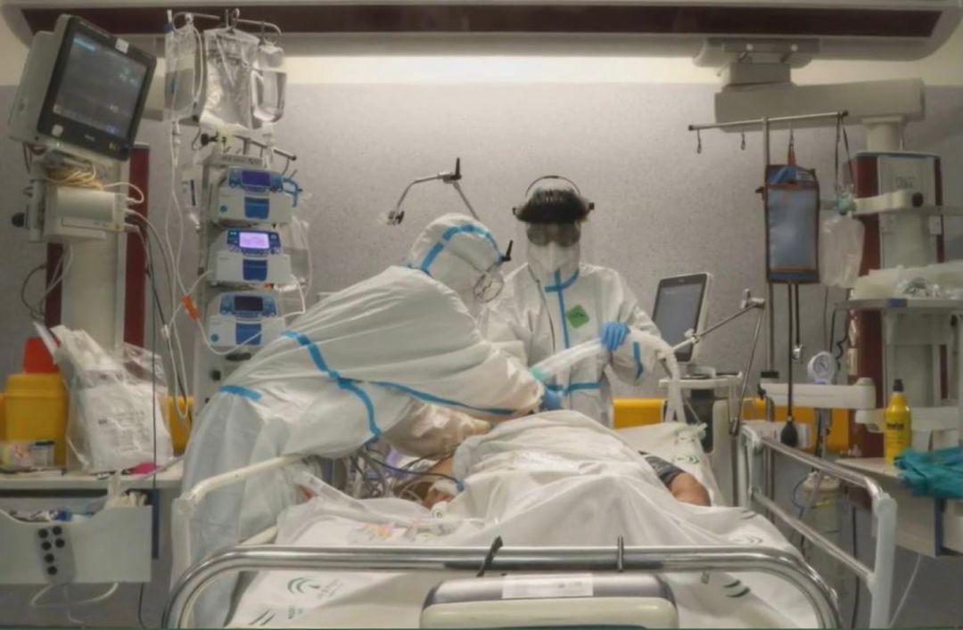 Personal médico atiende a un paciente en UCI Personal médico atiende a un paciente en UCI