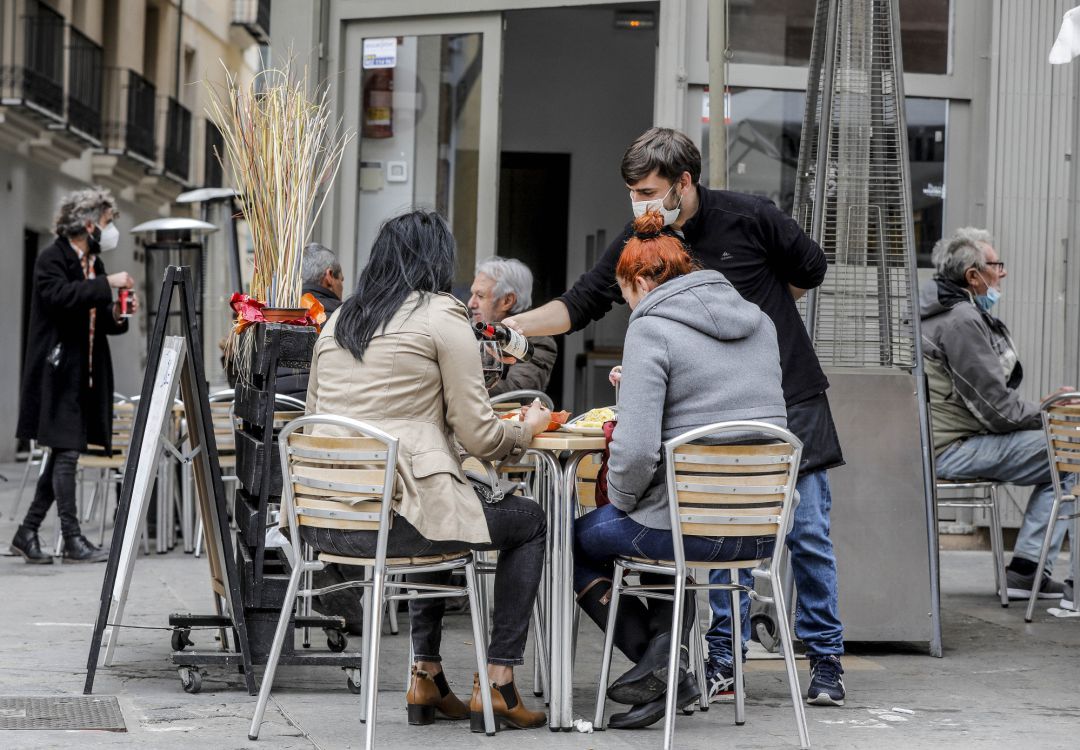 Un camarero atiende a dos clientas en una terraza el primer día de la apertura de la hostelería en València. Un camarero atiende a dos clientas en una terraza el primer día de la apertura de la hostelería en València.