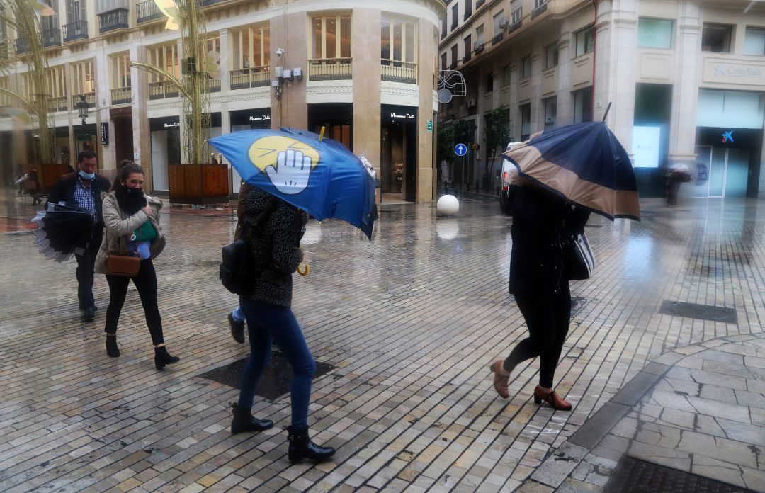 Archivo - Varias personas intentan resguardarse con el paraguas ante la lluvia y el viento Archivo - Varias personas intentan resguardarse con el paraguas ante la lluvia y el viento