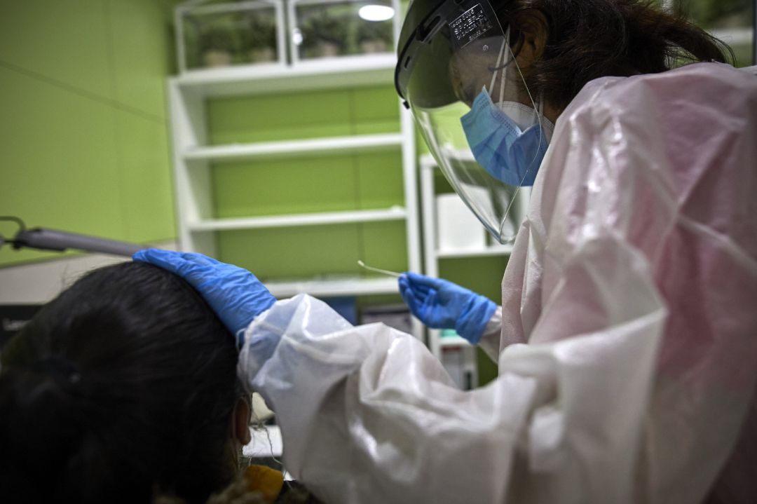 Una profesional sanitaria atiende a una paciente durante la realización de una prueba PCR Una profesional sanitaria atiende a una paciente durante la realización de una prueba PCR