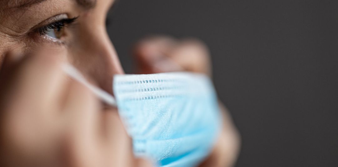 Una mujer se coloca una mascarilla Una mujer se coloca una mascarilla
