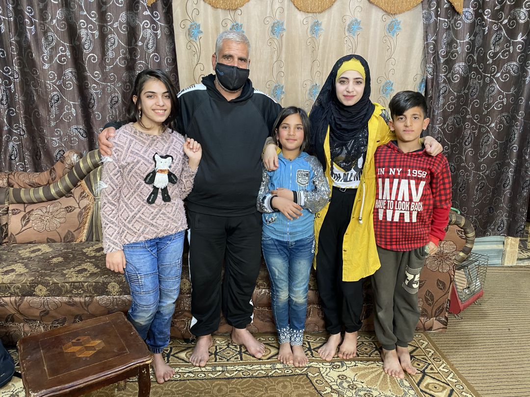 Maram, de amarillo, junto a varios de sus 6 hermanos y su padre, Mahmud Maram, en el “salón” de la caseta metálica en la que vive desde hace 9 años en este campo de refugiados. Maram, de amarillo, junto a varios de sus 6 hermanos y su padre, Mahmud Maram, en el “salón” de la caseta metálica en la que vive desde hace 9 años en este campo de refugiados.