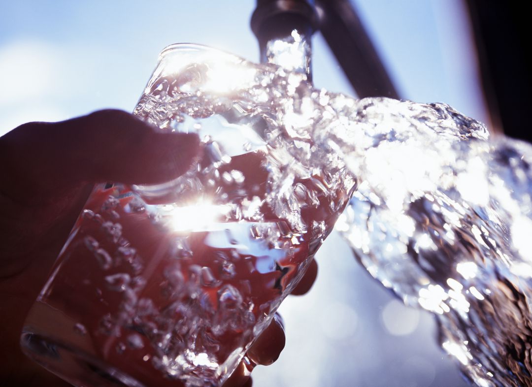 Una persona llena un vaso de agua Una persona llena un vaso de agua