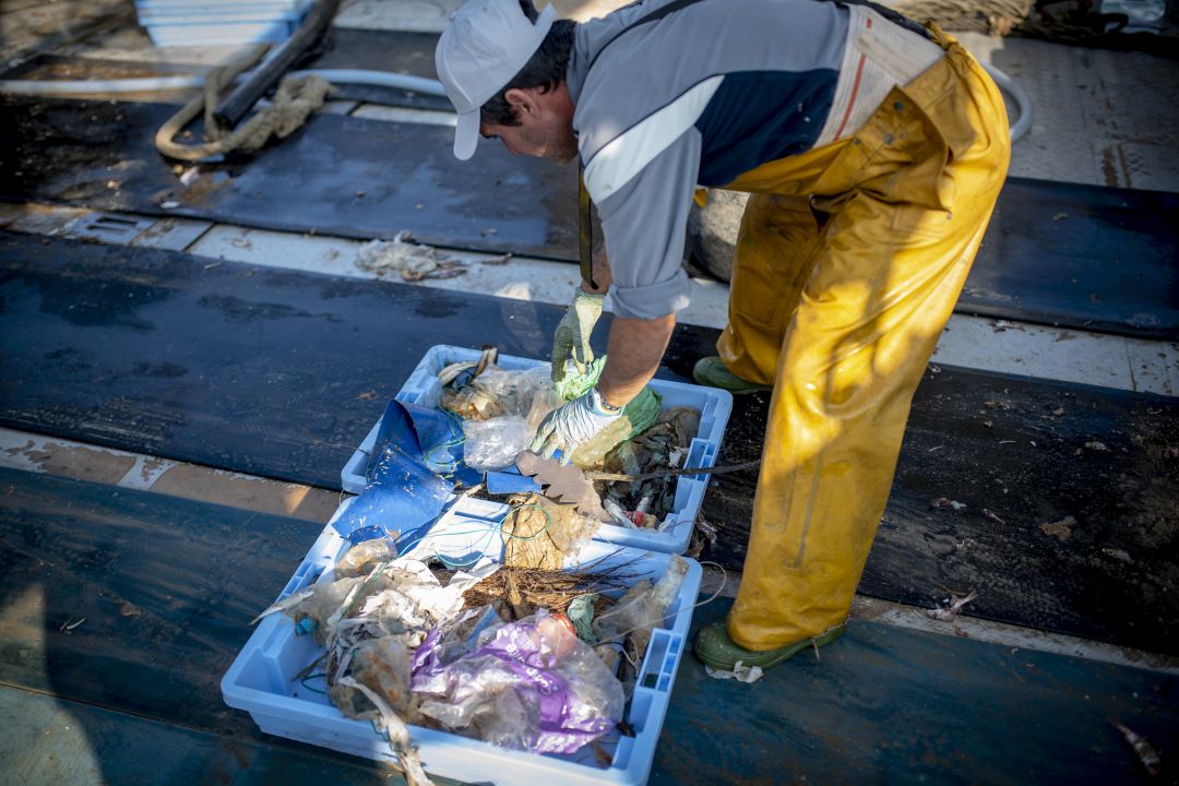 Un pescador selecciona los residuos Un pescador selecciona los residuos