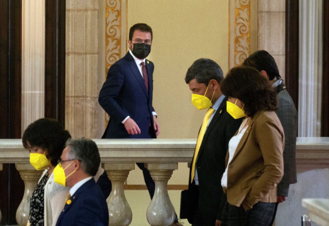 El candidato de ERC, Pere Aragonés, junto a varios diputados de JxCat, en los pasillos del Parlament. El candidato de ERC, Pere Aragonés, junto a varios diputados de JxCat, en los pasillos del Parlament.