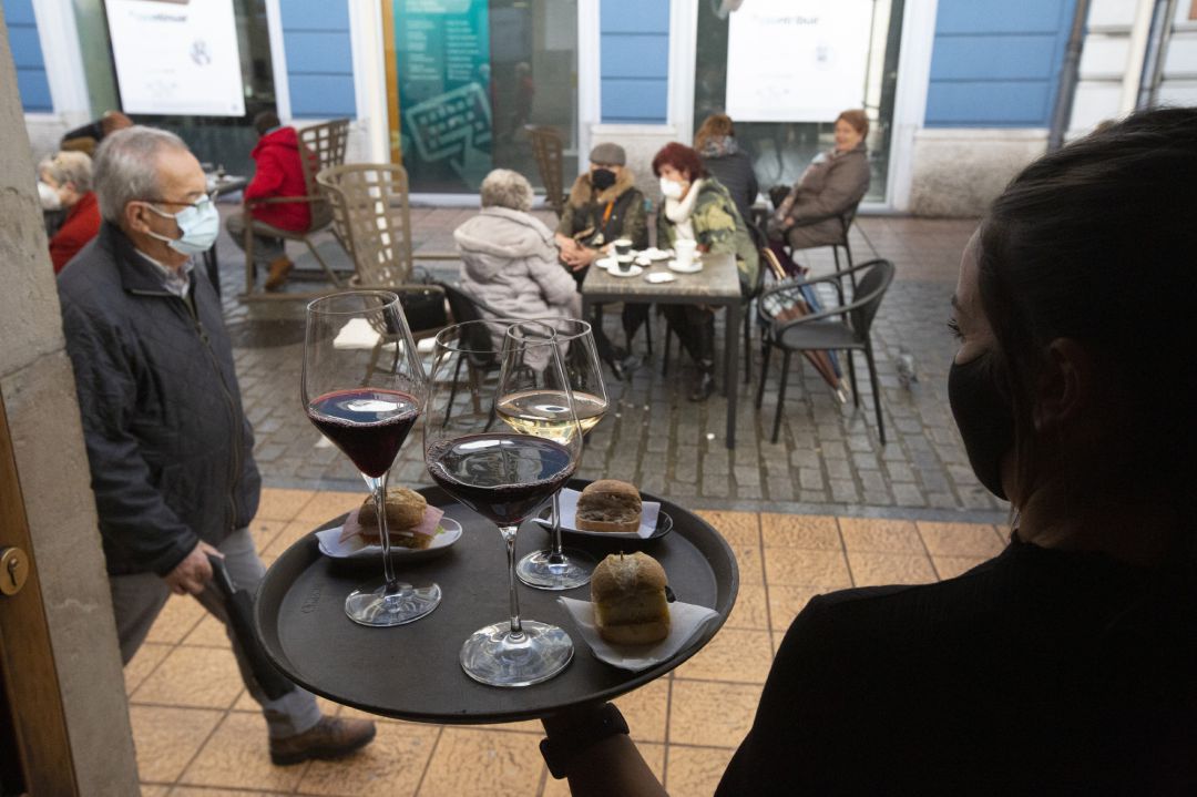 Un camarero transporta las consumiciones hacia su terraza. Un camarero transporta las consumiciones hacia su terraza.