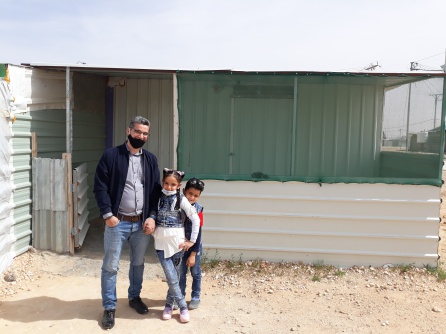 Hamed, junto a dos de sus hijos, frente a su taller Hamed, junto a dos de sus hijos, frente a su taller