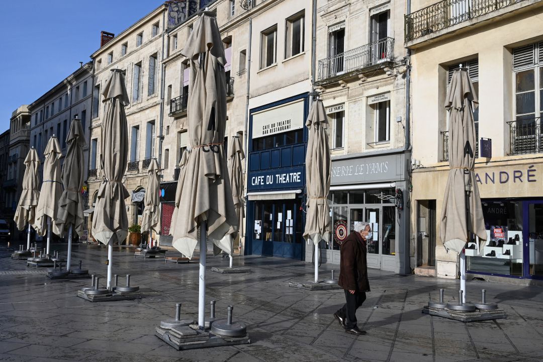 Una persona pasea por una calle con los restaurantes cerrados por la pandemia de COVID-19 Una persona pasea por una calle con los restaurantes cerrados por la pandemia de COVID-19