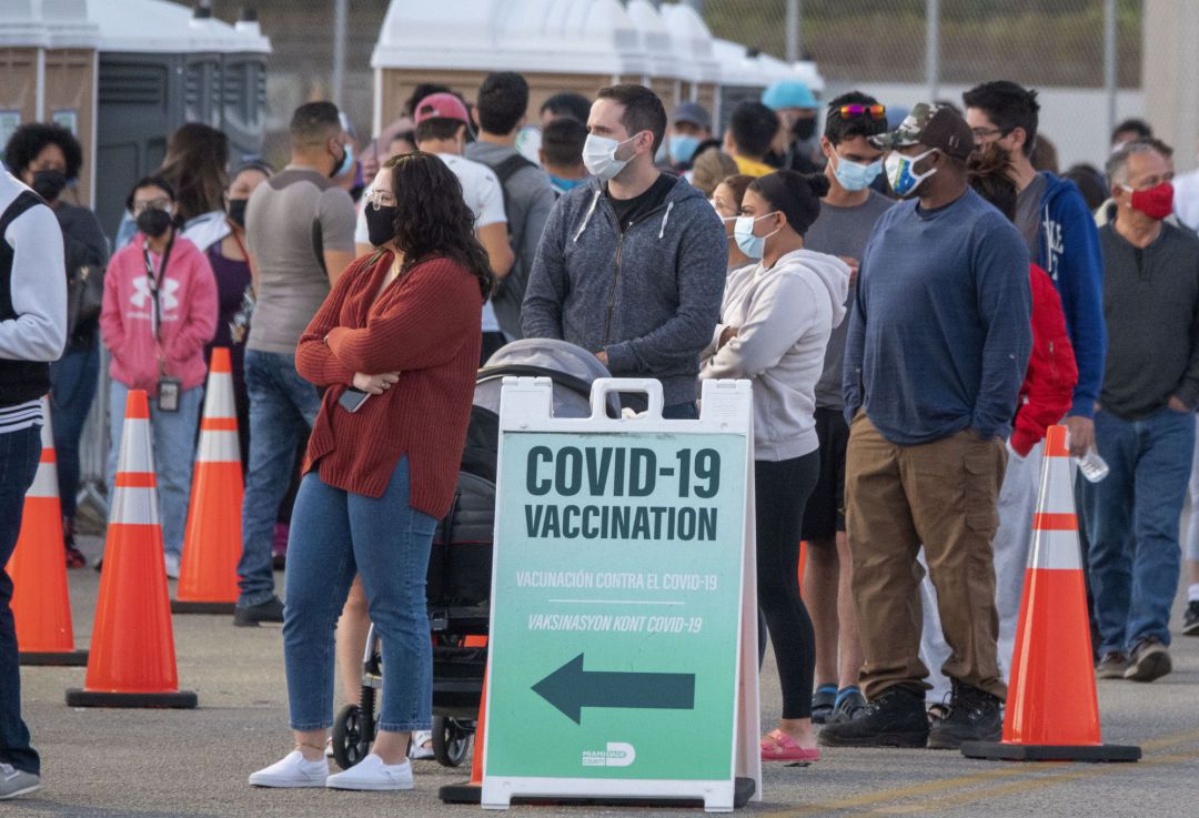 Varios ciudadanos norteamericanos esperan su turno de vacunación en la puerta de un colegio en Miami Varios ciudadanos norteamericanos esperan su turno de vacunación en la puerta de un colegio en Miami