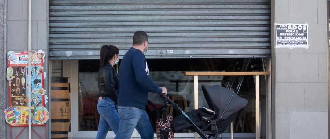 Dos personas pasan por delante de un establecimiento cerrado el mismo día de la entrada en vigor de nuevas restricciones impuestas por la crisis del Covid-19 Dos personas pasan por delante de un establecimiento cerrado el mismo día de la entrada en vigor de nuevas restricciones impuestas por la crisis del Covid-19