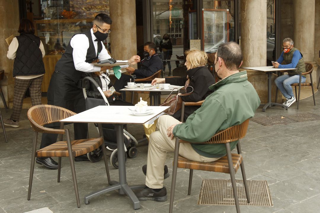 Archivo - Un camarero atiende a varios clientes en la terraza de un bar en Palma. Archivo - Un camarero atiende a varios clientes en la terraza de un bar en Palma.