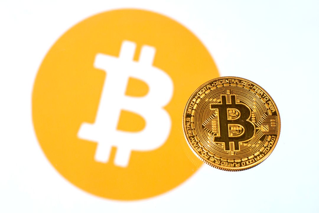 Un bitcoin sobre el logo de esta criptomoneda. Un bitcoin sobre el logo de esta criptomoneda.