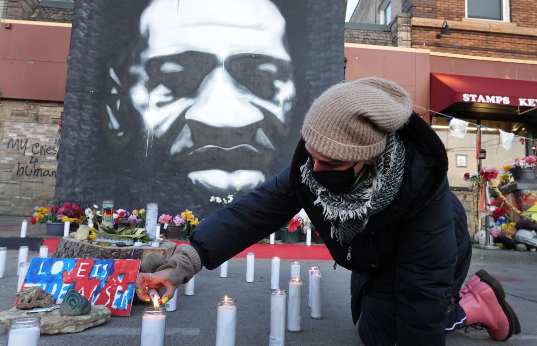 Activistas comunitarios encienden velas en un monumento cerca del sitio donde murió George Floyd. Activistas comunitarios encienden velas en un monumento cerca del sitio donde murió George Floyd.