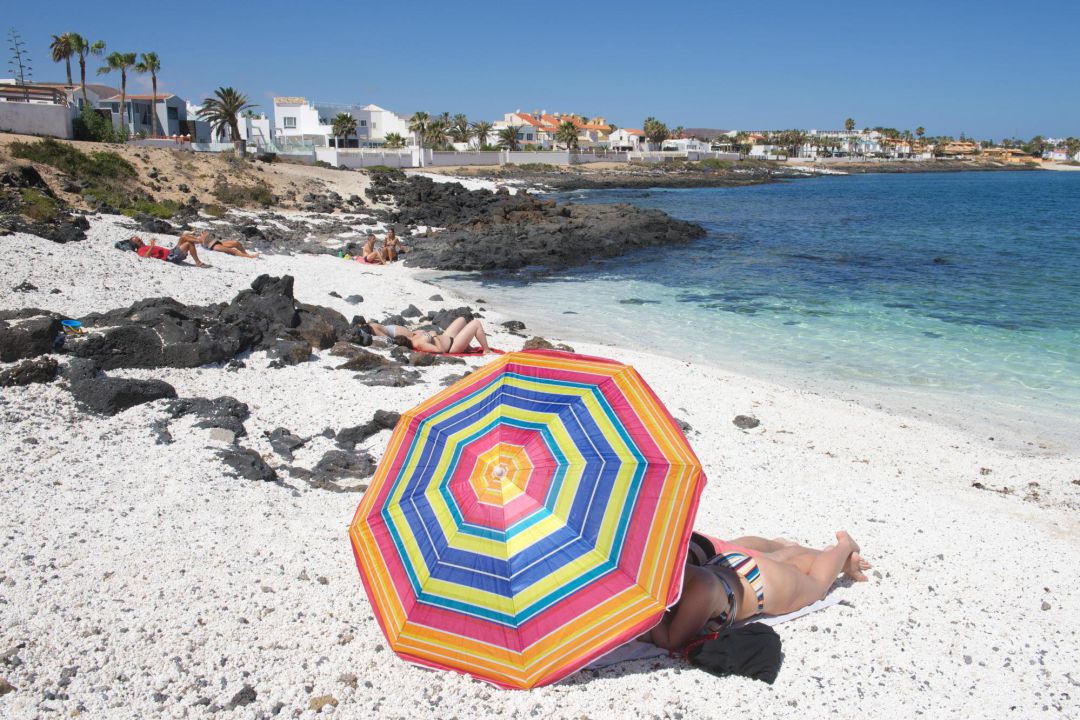 En la foto, turistas disfrutando de un día de playa en la localidad de Corralejo, en el norte de Fuerteventura En la foto, turistas disfrutando de un día de playa en la localidad de Corralejo, en el norte de Fuerteventura