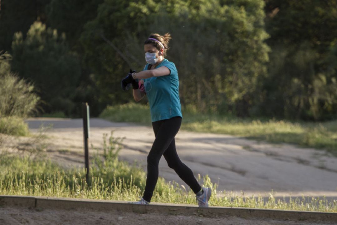 Una mujer corriendo con la mascarilla puesta. Una mujer corriendo con la mascarilla puesta.