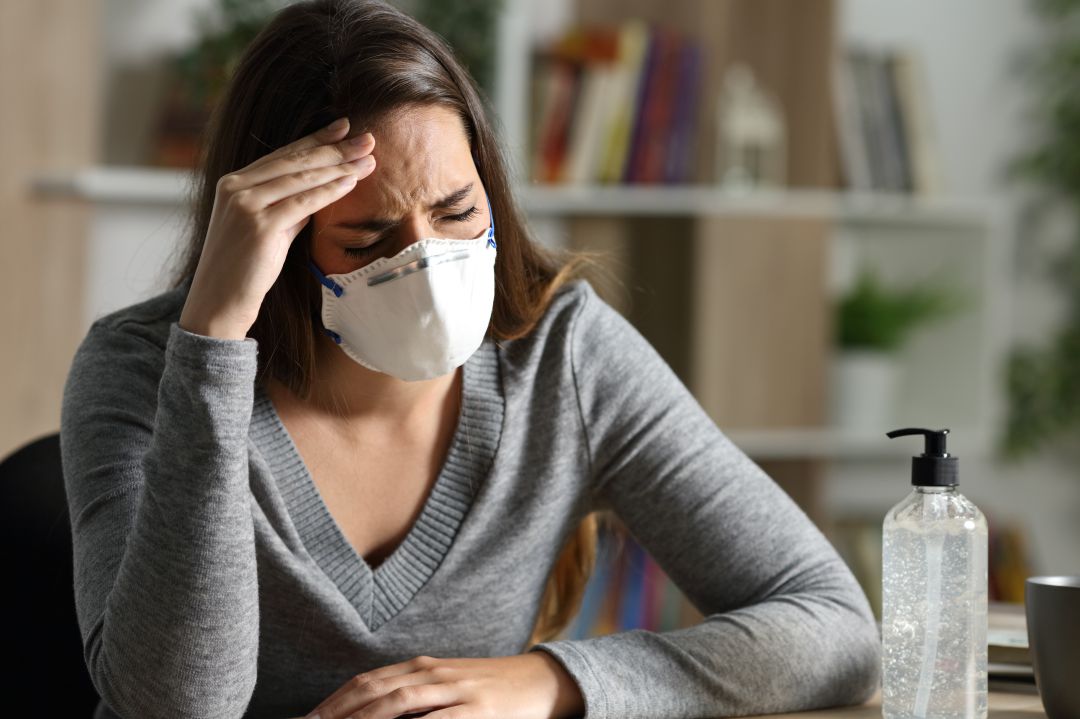 Una mujer siente un fuerte dolor de cabeza Una mujer siente un fuerte dolor de cabeza