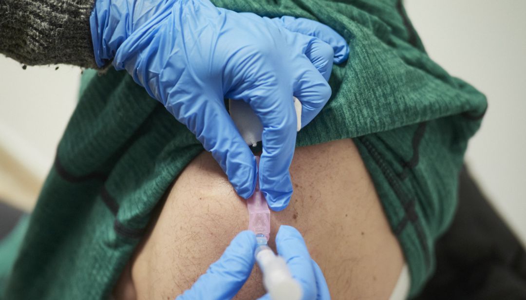 Una sanitaria vacuna contra el Covid-19 a una persona. Una sanitaria vacuna contra el Covid-19 a una persona.