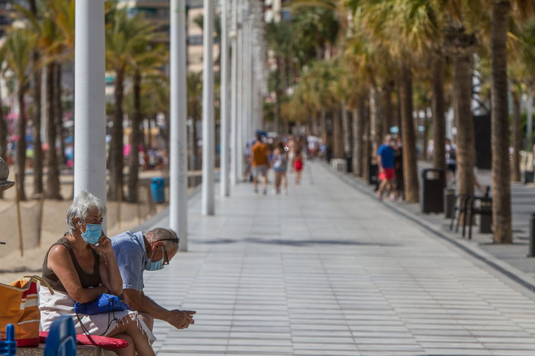 Dos personas descansan en el paseo marítimo de Benidorm Dos personas descansan en el paseo marítimo de Benidorm