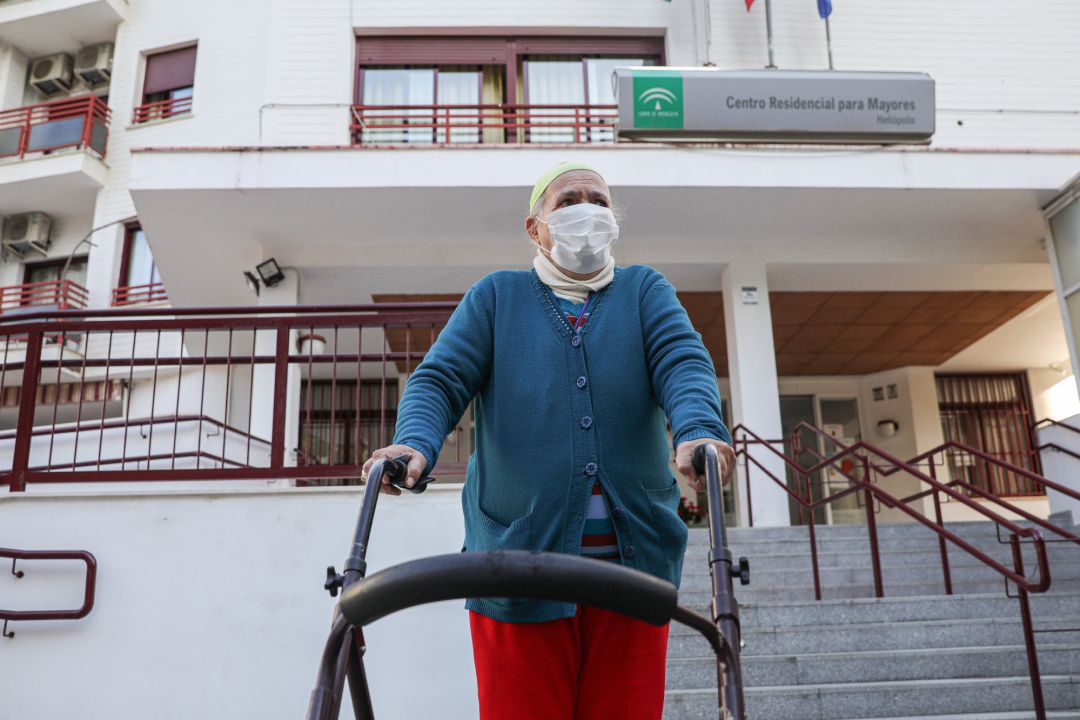 Una anciana sale de un centro residencial para mayores. Una anciana sale de un centro residencial para mayores.