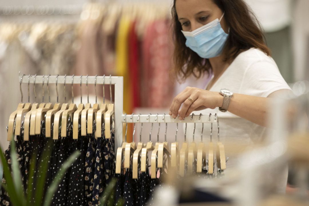 Archivo - Mujer con mascarilla en una tienda de ropa. Archivo - Mujer con mascarilla en una tienda de ropa.