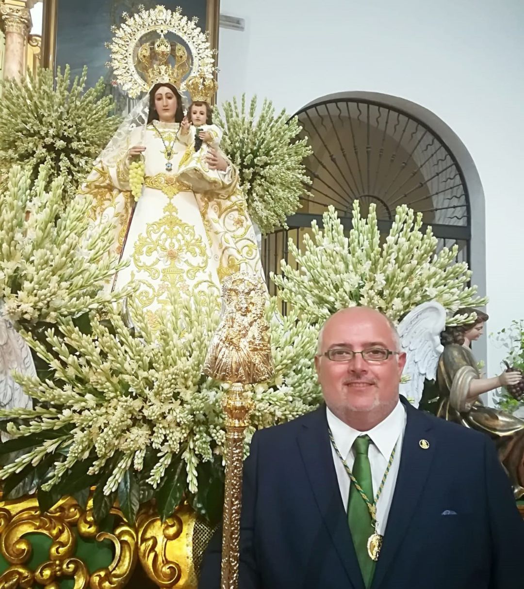 El presidente de la Hermandad posa con al patrona de fondo El presidente de la Hermandad posa con al patrona de fondo