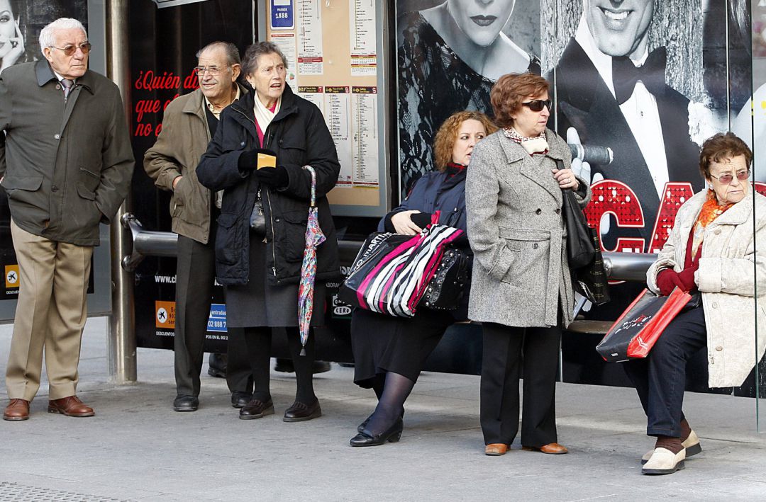Ancianos en la parada de un autobús Ancianos en la parada de un autobús