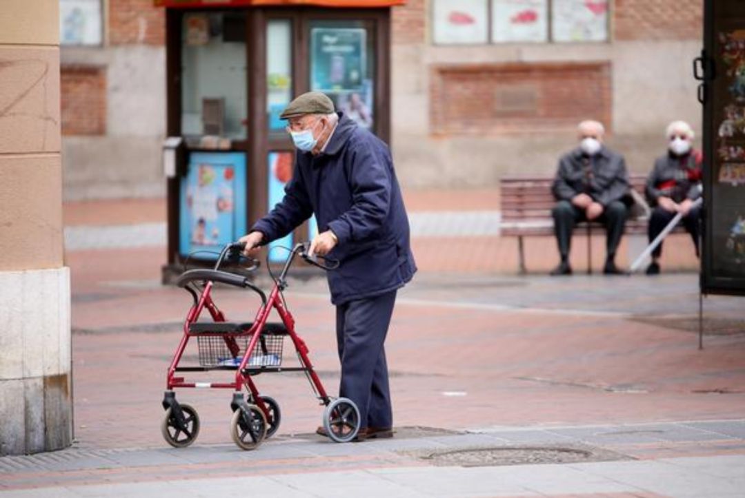Personas mayores paseando por las inmediaciones de una residencia Personas mayores paseando por las inmediaciones de una residencia