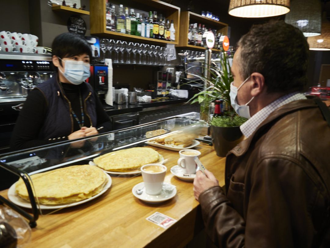imagen de archivo de una camarera y un cliente en el interior de un bar. imagen de archivo de una camarera y un cliente en el interior de un bar.