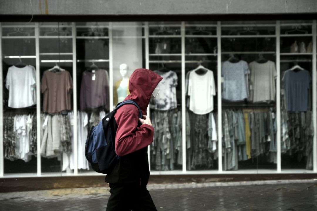 Archivo - Un hombre pasea frente a una tienda Archivo - Un hombre pasea frente a una tienda