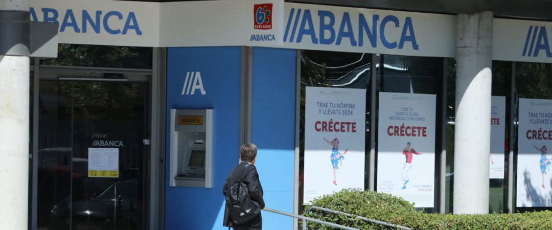 Archivo - Un hombre pasa al lado de una sucursal de Abanca Archivo - Un hombre pasa al lado de una sucursal de Abanca