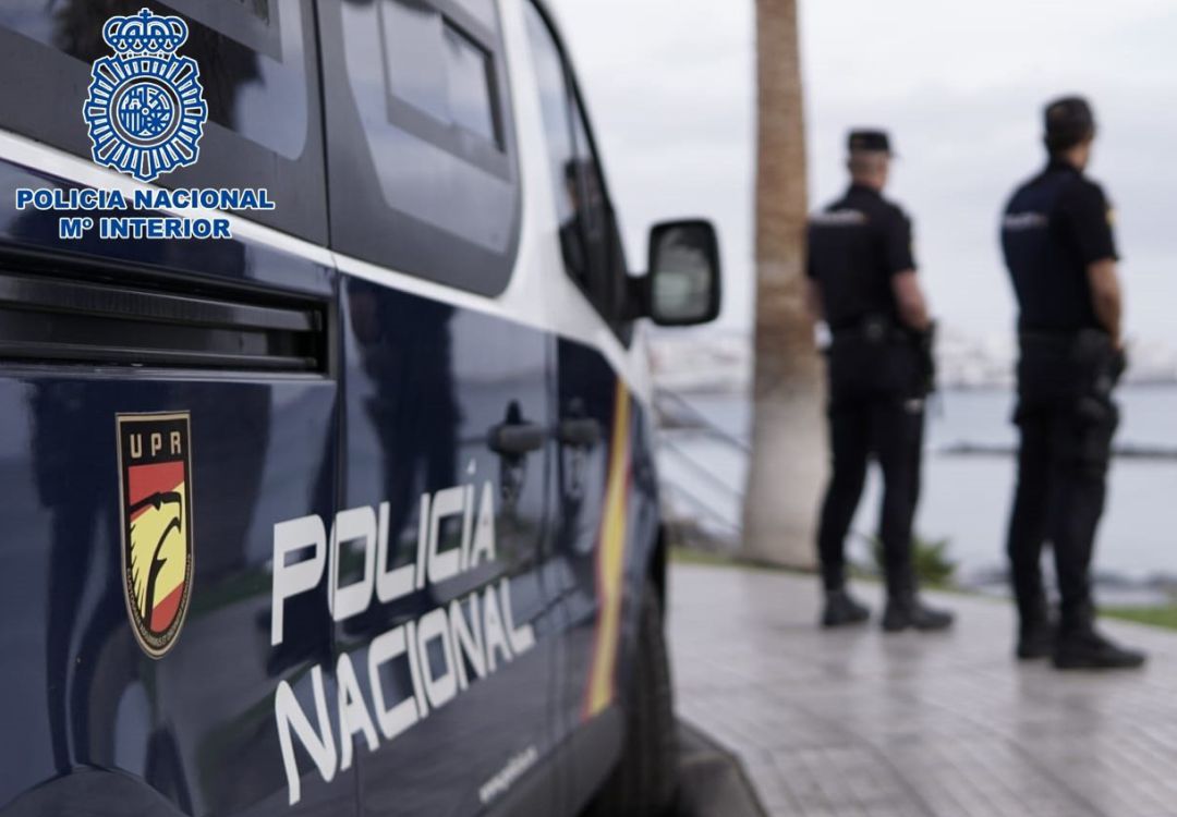 Agentes de la Policía Nacional junto a un coche patrulla. Agentes de la Policía Nacional junto a un coche patrulla.
