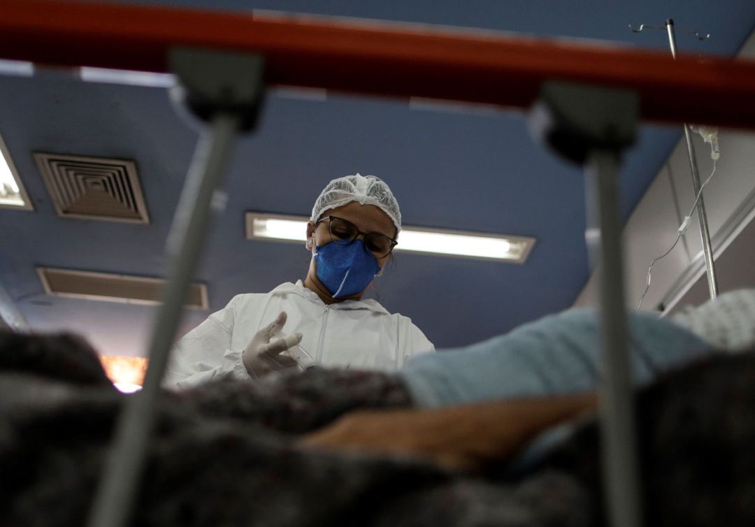 Una enfermera se prepara para aplicar una inyección a un paciente contagiado por covid-19 Una enfermera se prepara para aplicar una inyección a un paciente contagiado por covid-19