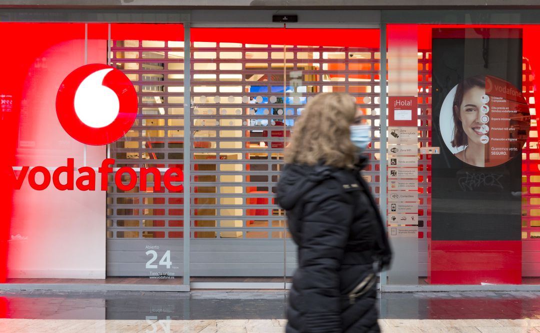 Una mujer pasea frente a una tienda de Vodafone. Una mujer pasea frente a una tienda de Vodafone.