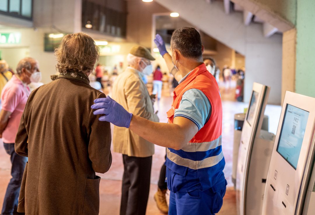 Una hombre de Protección Civil, dirige a las personas que van a recibir la vacunar contra el Covid-19, a 28 de abril de 2021, en el Estadio de la Cartuja, en Sevilla. Una hombre de Protección Civil, dirige a las personas que van a recibir la vacunar contra el Covid-19, a 28 de abril de 2021, en el Estadio de la Cartuja, en Sevilla.