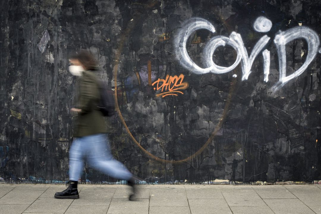 Una mujer pasa al lado de un grafitti del artista J.Warx en una vía de Valencia Una mujer pasa al lado de un grafitti del artista J.Warx en una vía de Valencia
