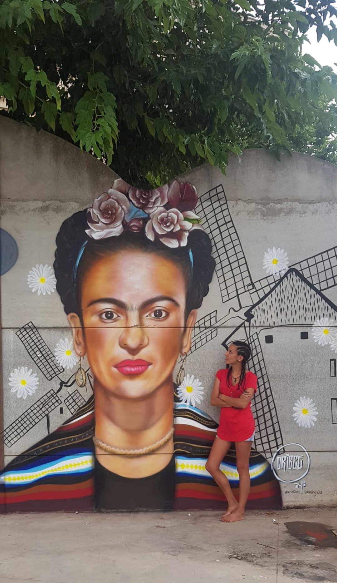 La artista iniestense posa junto a uno de sus murales La artista iniestense posa junto a uno de sus murales